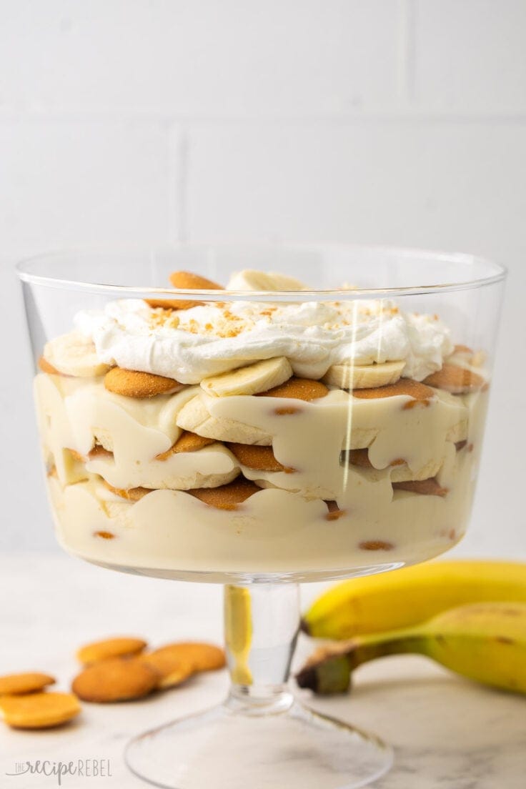 triffle bowl filled with banana pudding topped with whipped cream.