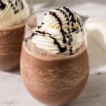 a glass of frozen hot chocolate topped with whipped cream.