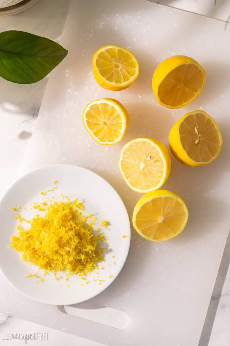 chopped lemons on a cutting board with a plate of lemon zest beside.