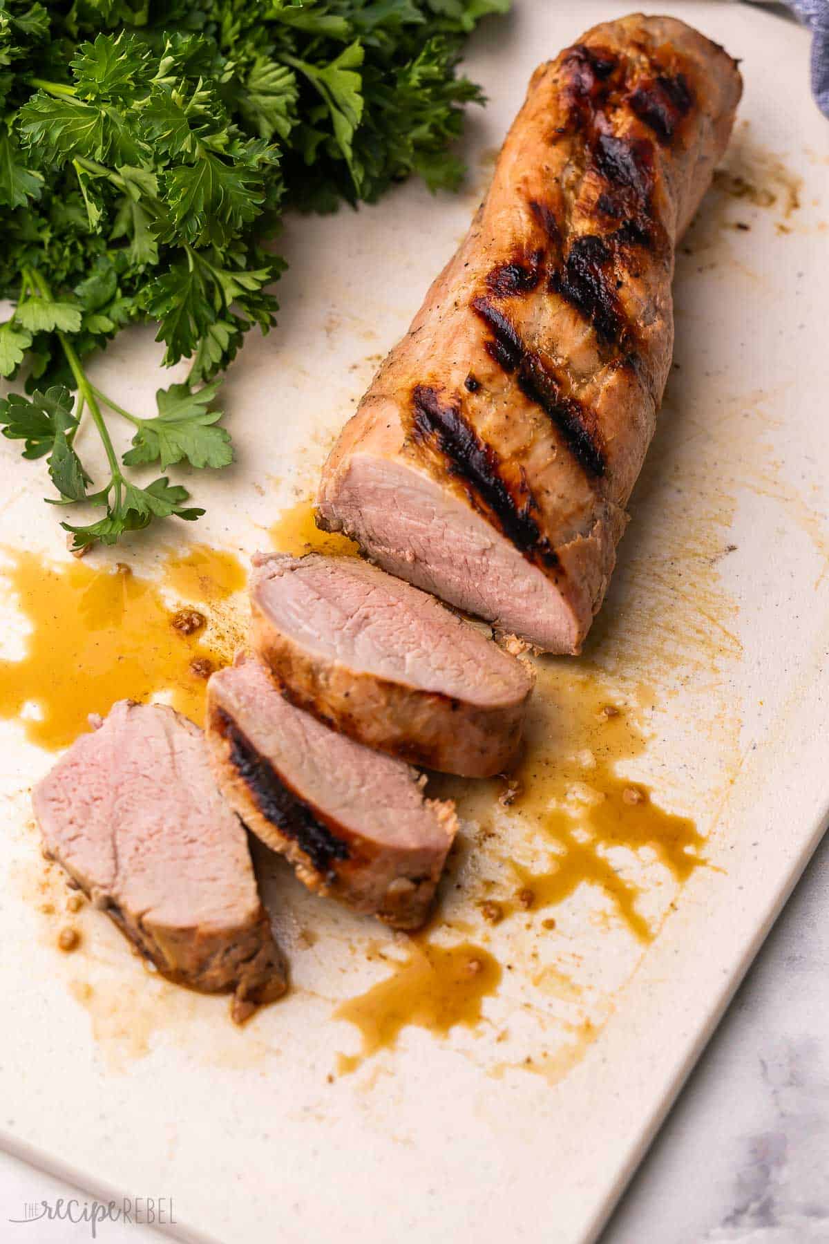 a sliced pork tenderloin on a cutting board.