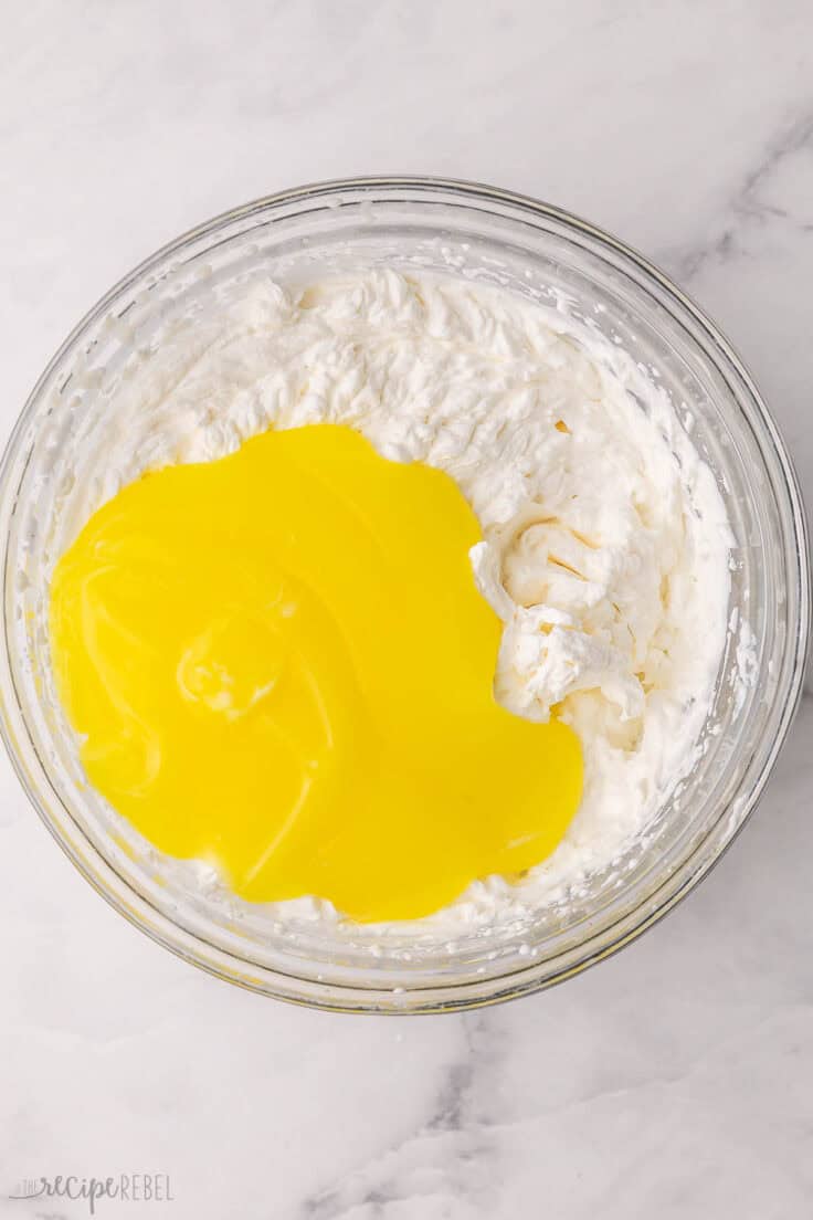 lemon curd added to bowl of whipped cream.