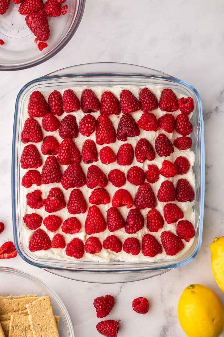 fully assembled lemon raspberry icebox cake topped with raspberries.