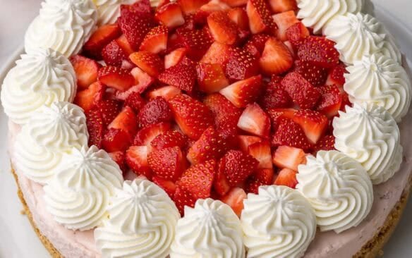 large strawberry cheesecake topped with chopped strawberries.