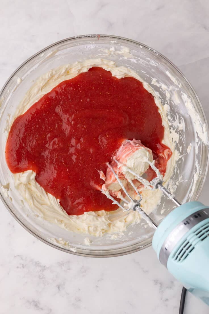 strawberry sauce added to bowl of cream cheese.