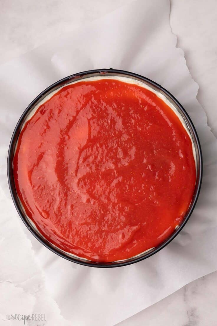 strawberry lemonade cheesecake fully assembled in pan.