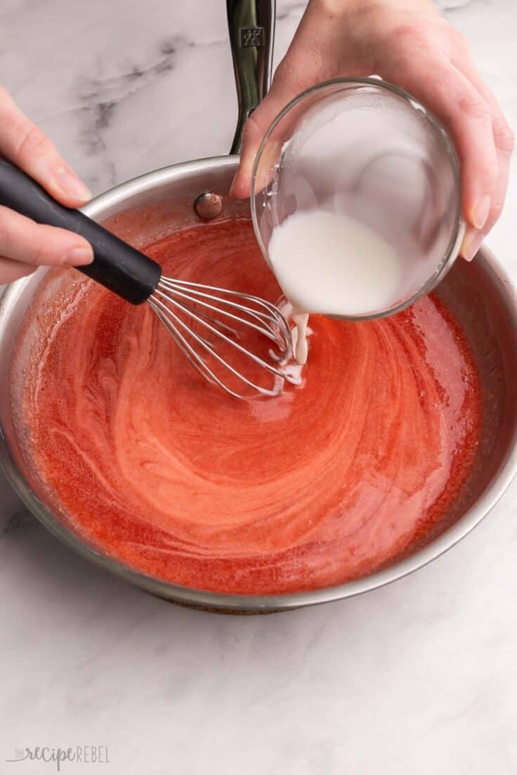 cornstarch mixture being whisked into other ingredients.