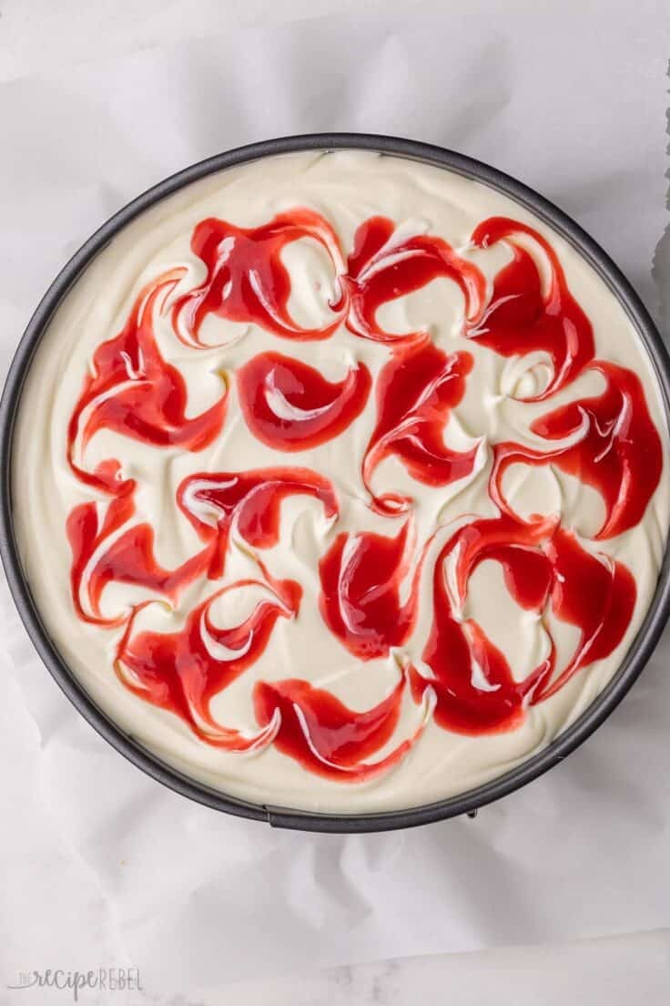 fully prepared white chocolate raspberry cheesecake in pan.