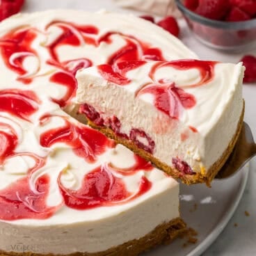 a piece of white chocolate raspberry cheesecake being served.