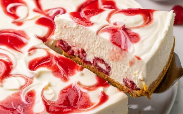 a piece of white chocolate raspberry cheesecake being served.