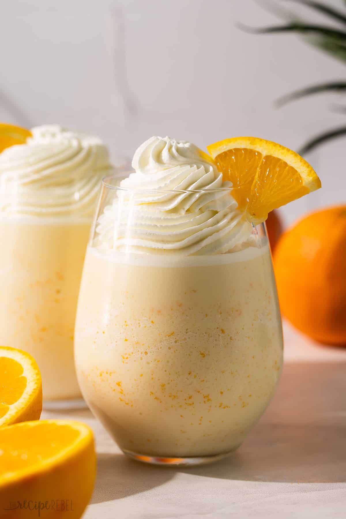 oranges and two glasses of orange creamsicle slushy.