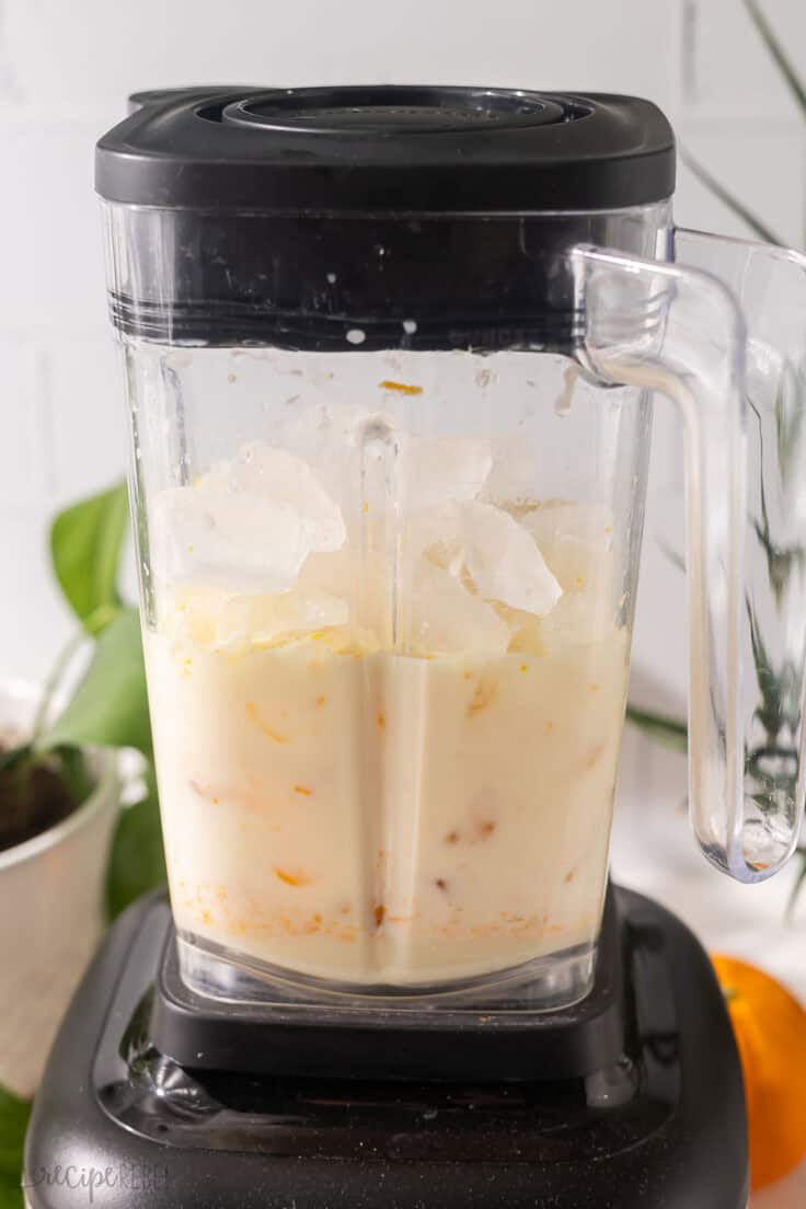 blender filled with orange creamsicle slushy ingredients.