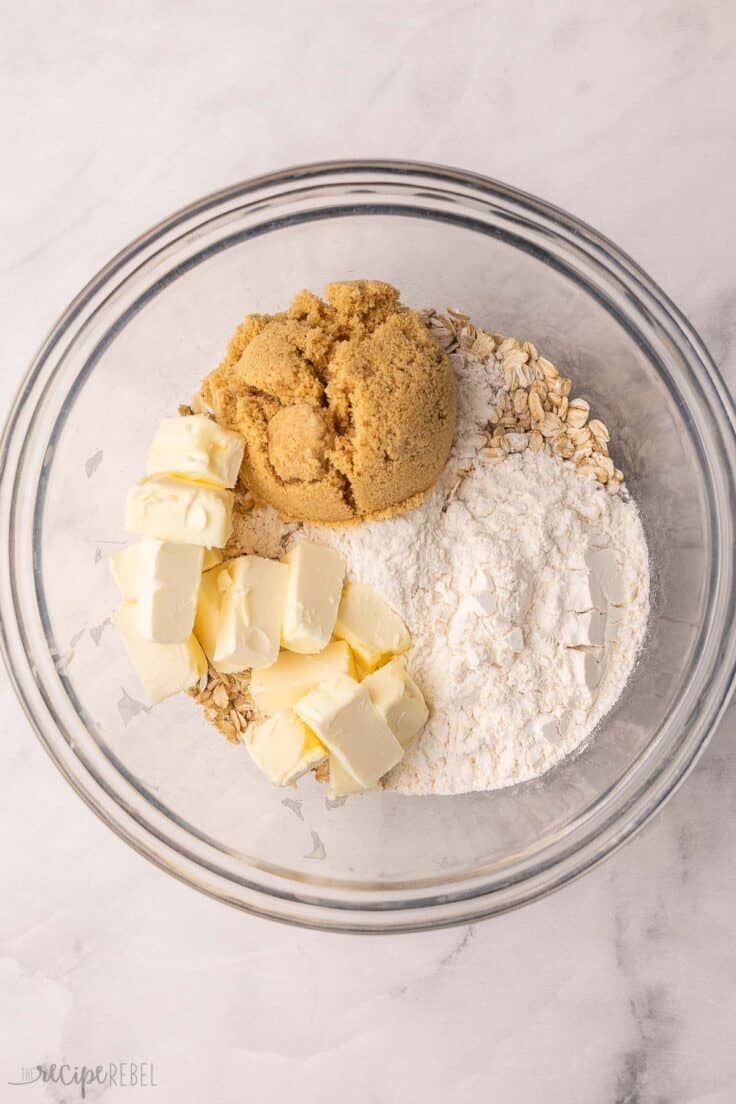 butter, oats and other unmixed ingredients in a glass bowl.