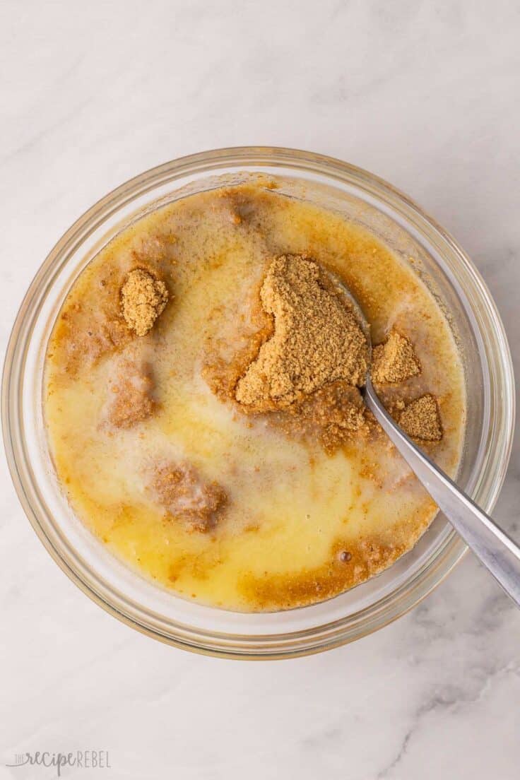 glass mixing bowl with graham crumbs and melted butter.