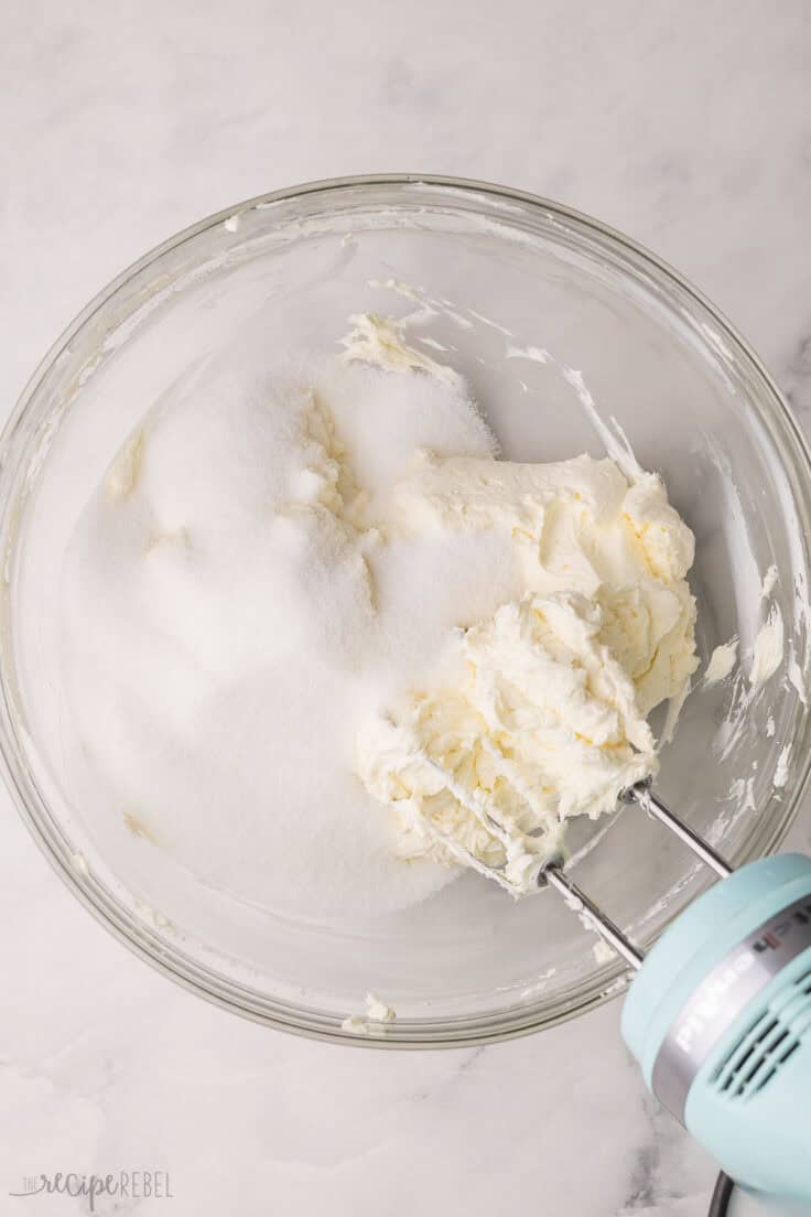 glass mixing bowl with cream cheese and sugar added.