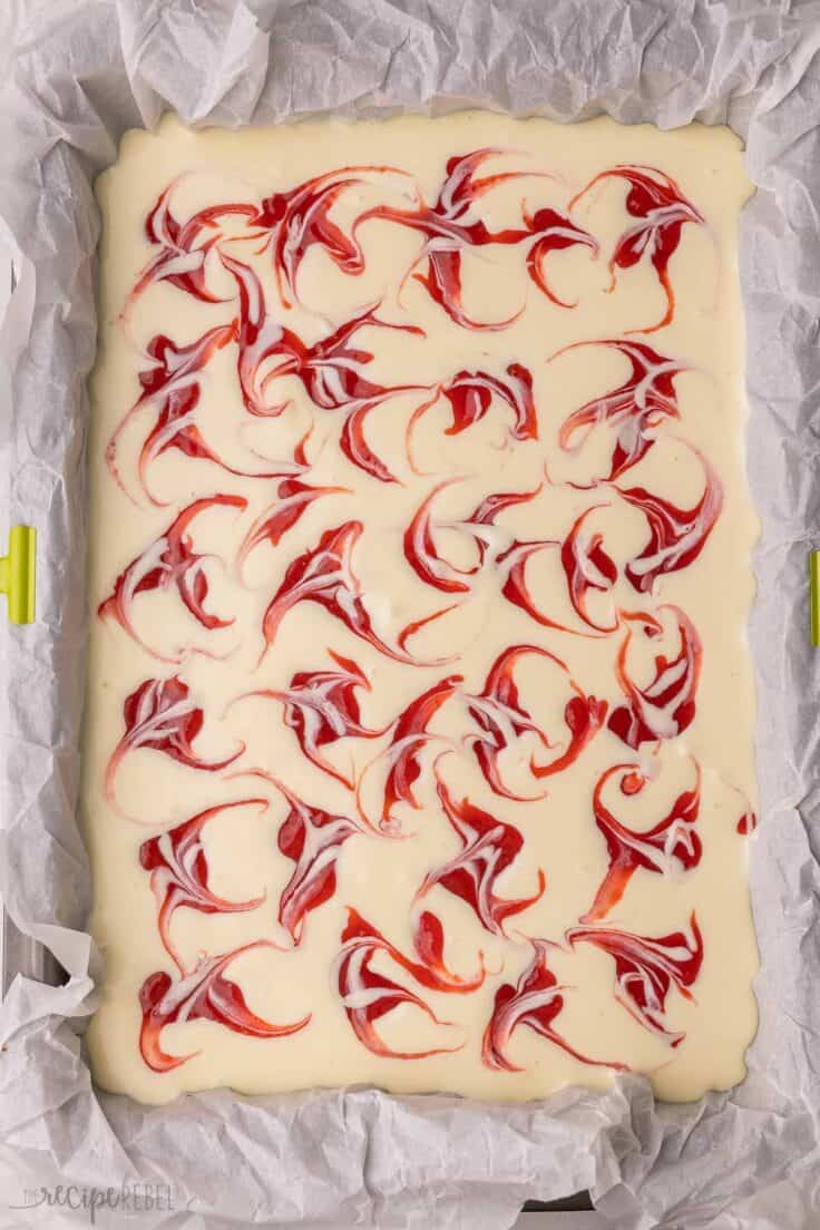 unbaked strawberry swirl cheesecake in pan.
