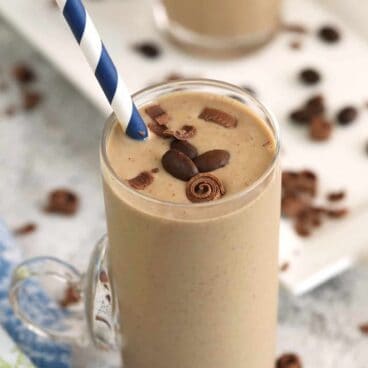 coffee smoothie in a glass with a paper straw.