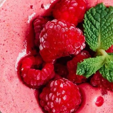 raspberry smoothie with raspberries on top.