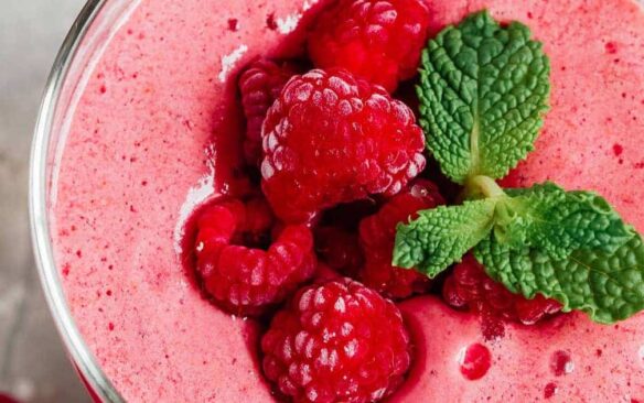 raspberry smoothie with raspberries on top.