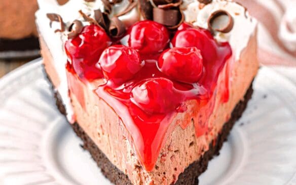 slice of no bake Black Forest cheesecake on a white plate.