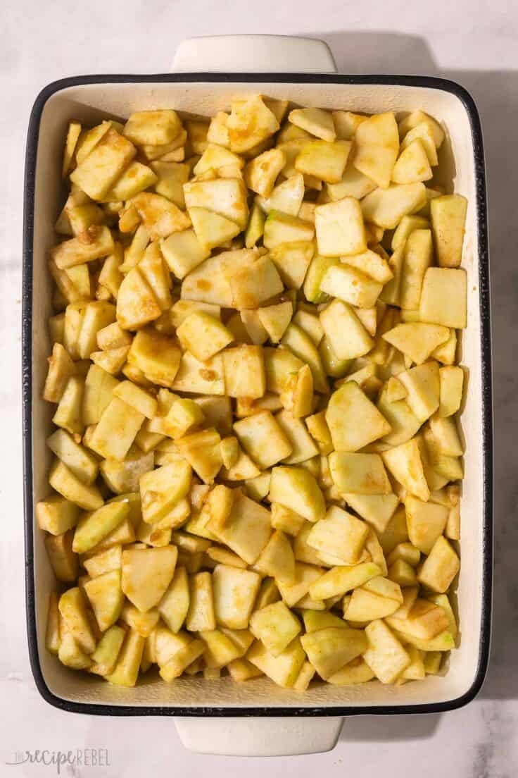 large baking dish with chopped apples spread in bottom.