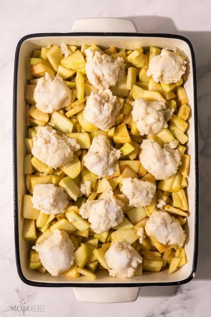 cobbler dough added to the top of chopped apples in pan.