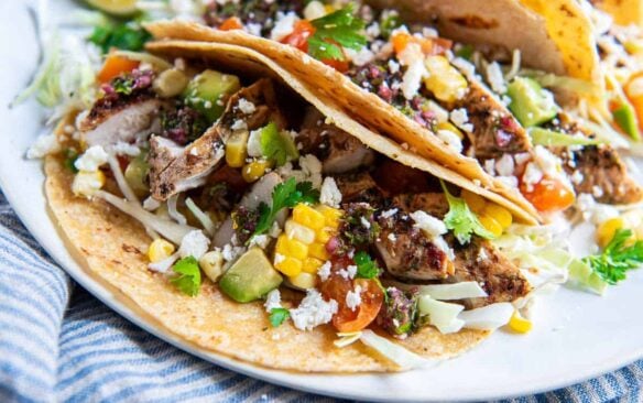 close up of chimchurri chicken tacos on a white plate