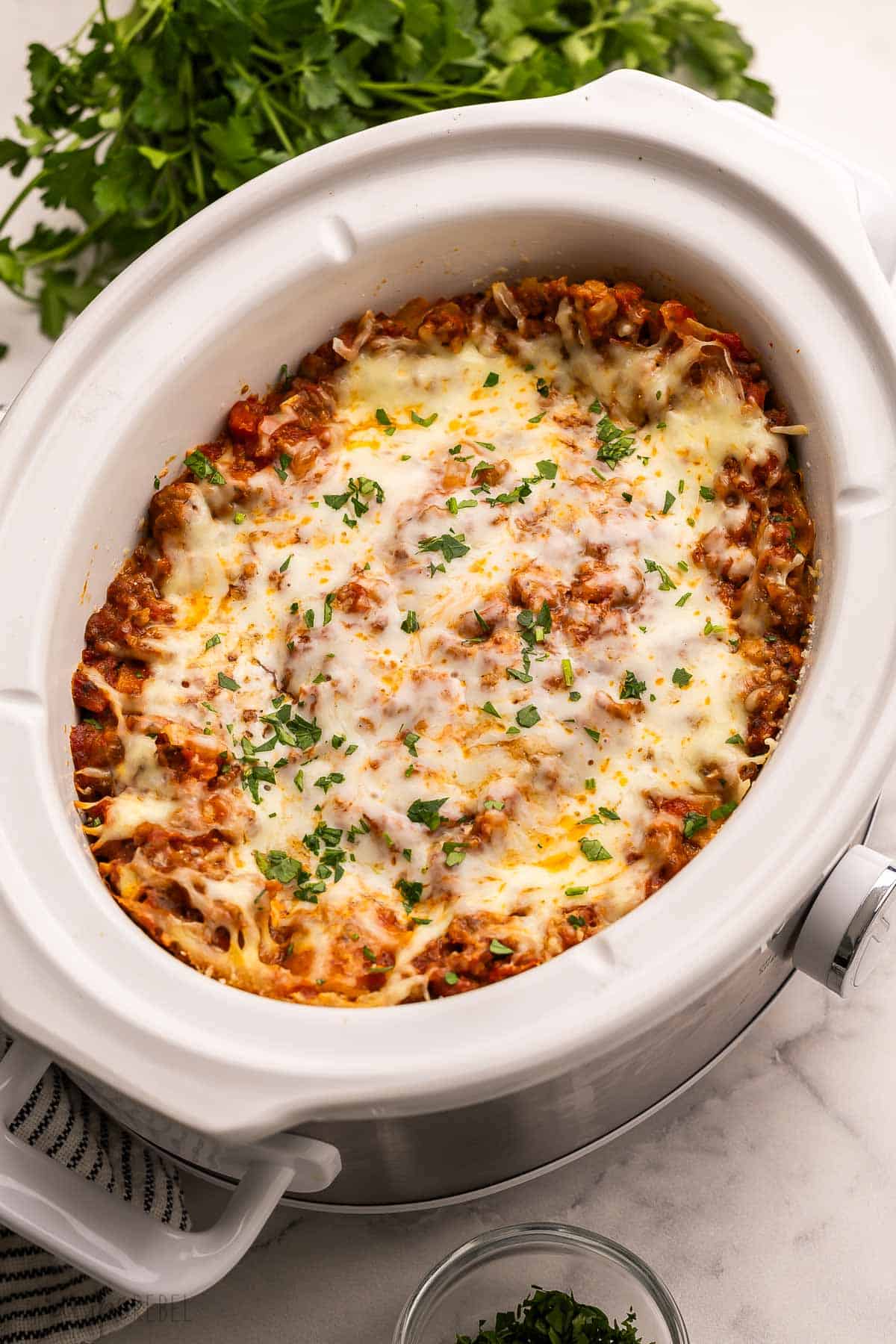 white crockpot full of crockpot lasagna.