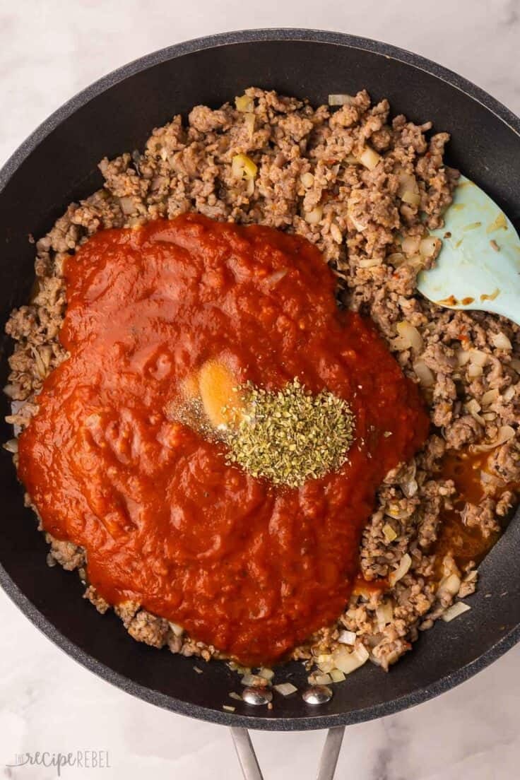 sauce and spices added to other ingredients in pan.