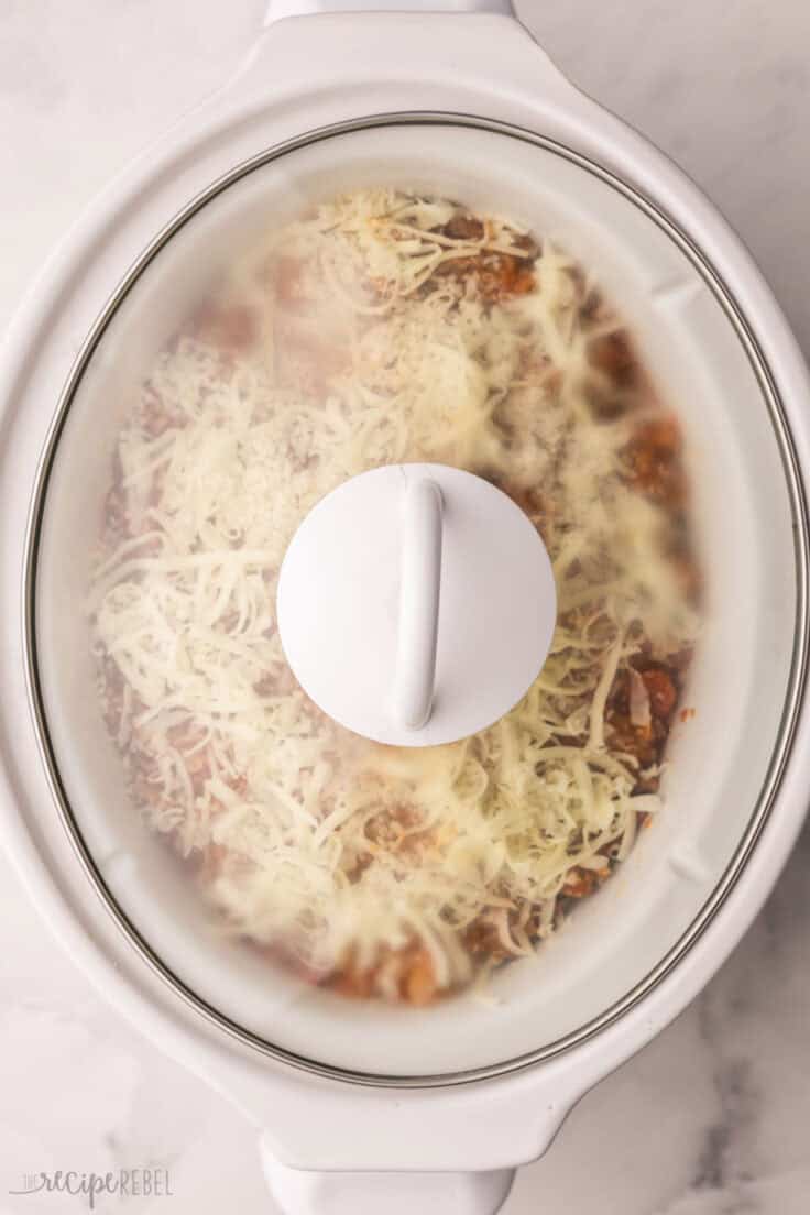 glass lid on crockpot full of lasagna.