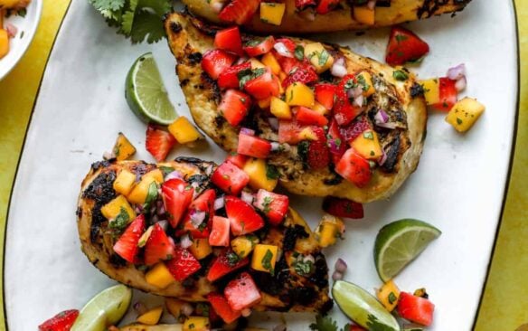 grilled strawberry and mango chicken on a white serving plate