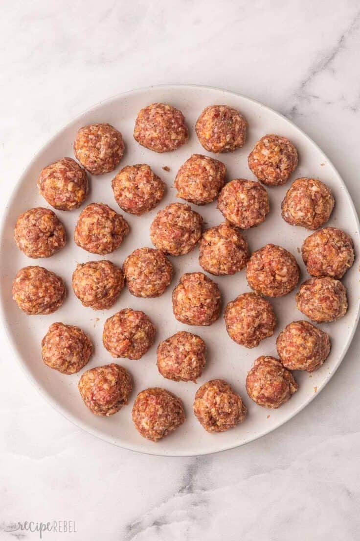 white plate filled with rolled meatballs.