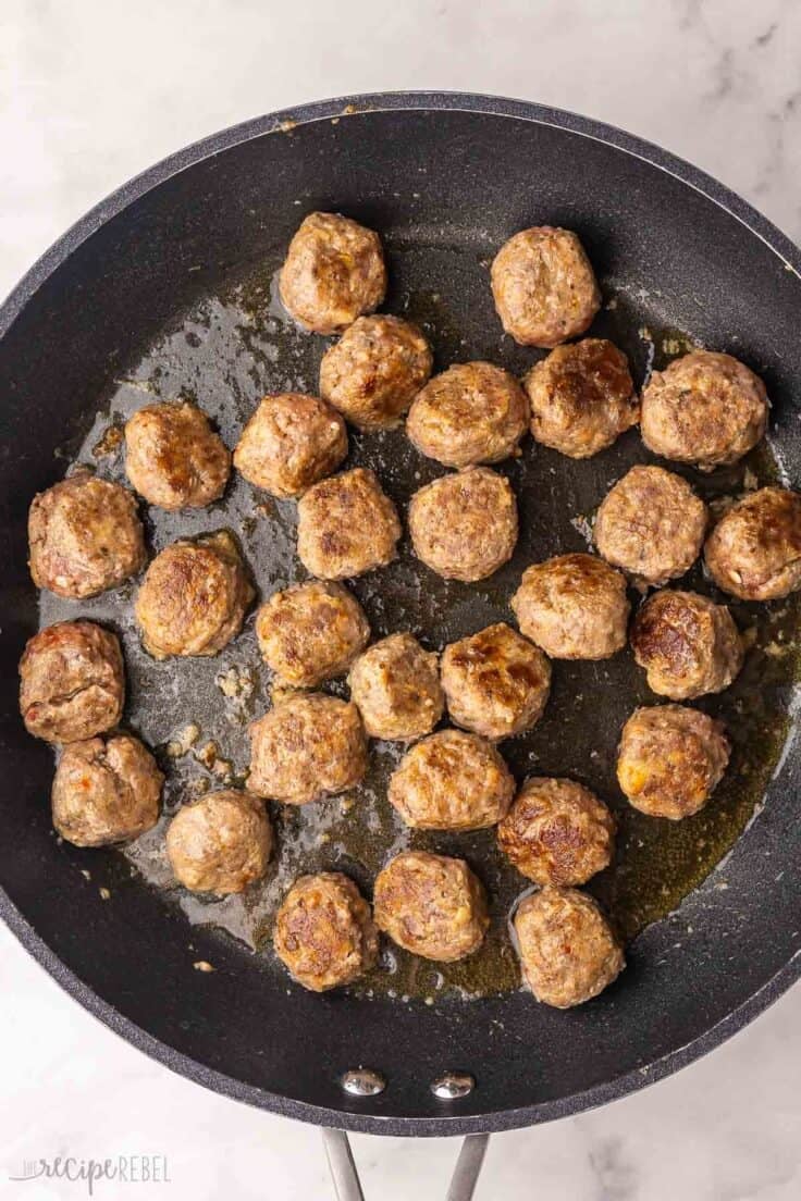 black pan filled with cooked meatballs.
