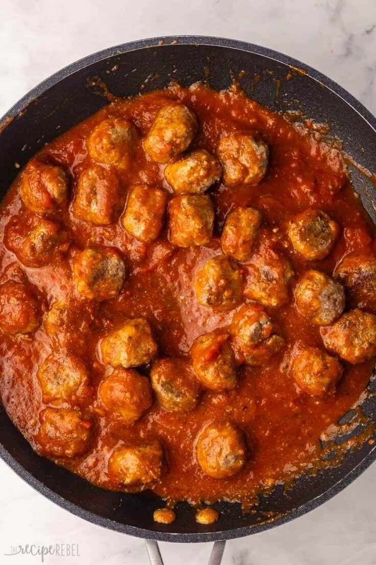 meatballs and sauce in a black pan.