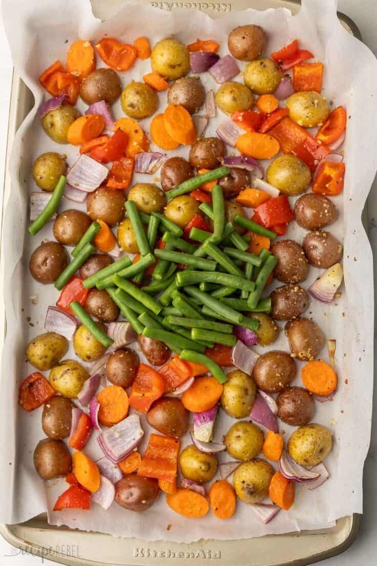 green beans added to other vegetables in pan.