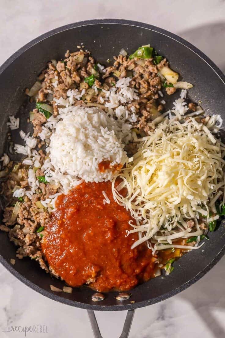 cheese, rice and sauce added to other ingredients in pan.