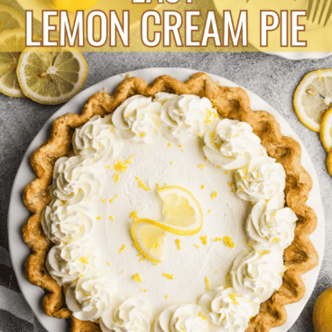 lemon cream pie on a gray background with lemons in a bowl to the side.