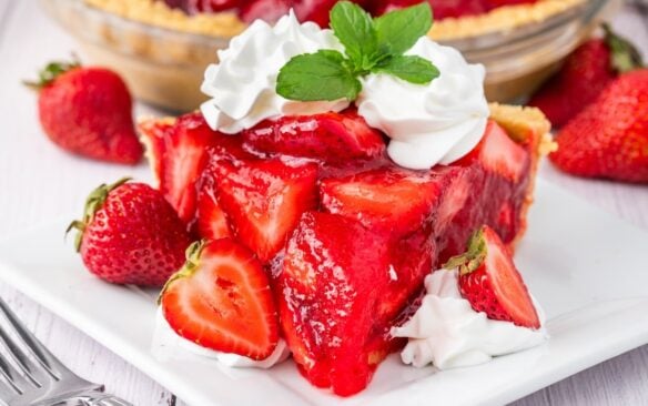 slice of fresh strawberry pie on a white plate.