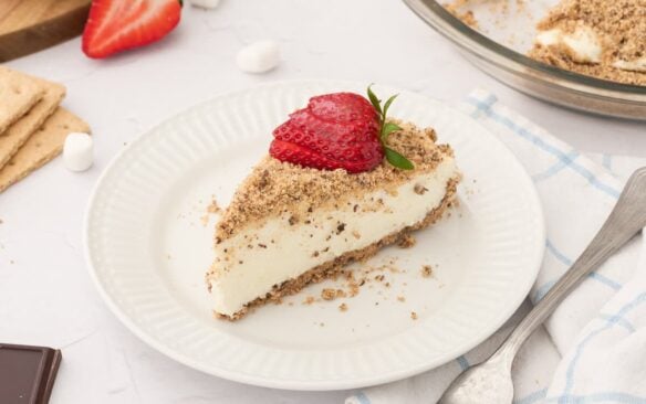 slice of marshmallow pie on a white plate with strawberry on top.