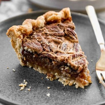 slice of pecan pie on a grey plate.