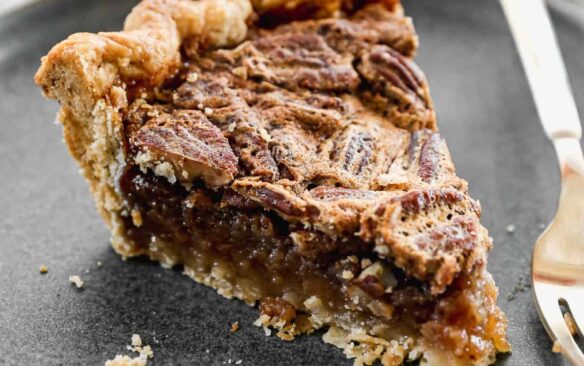 slice of pecan pie on a grey plate.