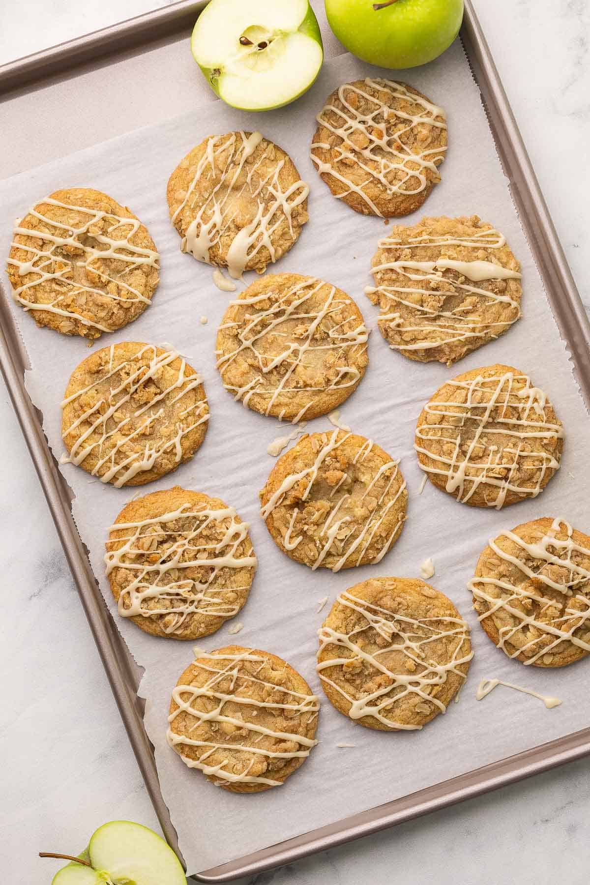 overhead image of apple cookies on a parchment lined sheet pan.