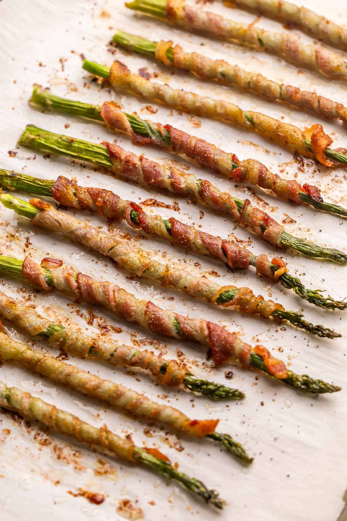 Bacon Wrapped Asparagus is an elegant yet easy side dish or appetizer made with slices of thin-cut bacon wrapped around asparagus stalks, sprinkled with seasonings, and baked until crispy. #appetizer #recipe | appetizer recipes | side dishes | vegetables | roast vegetables bacon wrapped asparagus out of the oven.