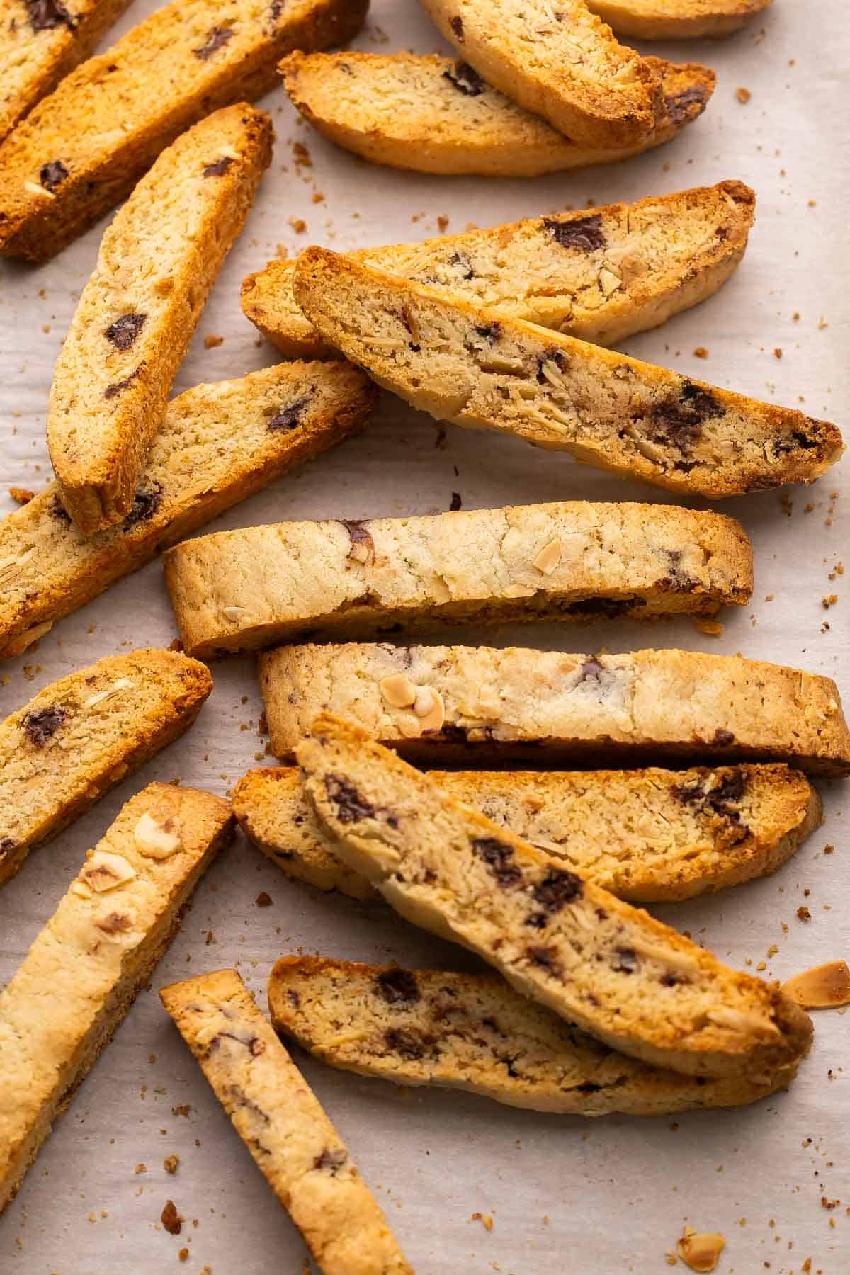 These Chocolate Almond Biscotti cookies are twice-baked Italian cookies made with basic pantry staples and can be customized with your favorite add-ins. So easy to make and perfect for dunking in a cup of coffee! #cookie #dessert #recipe | baking recipe | almond biscotti recipe | biscotti cookies | almond cookies | dark chocolate | christmas cookies | italian biscotti baked biscotti slices on parchment paper.