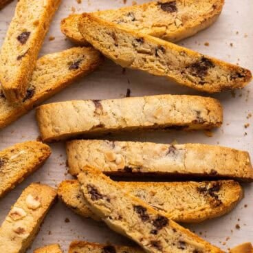 close up of slices of biscotti on parchment paper.