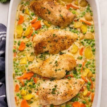 square image of chicken casserole with chicken breasts and vegetables in a creamy sauce.