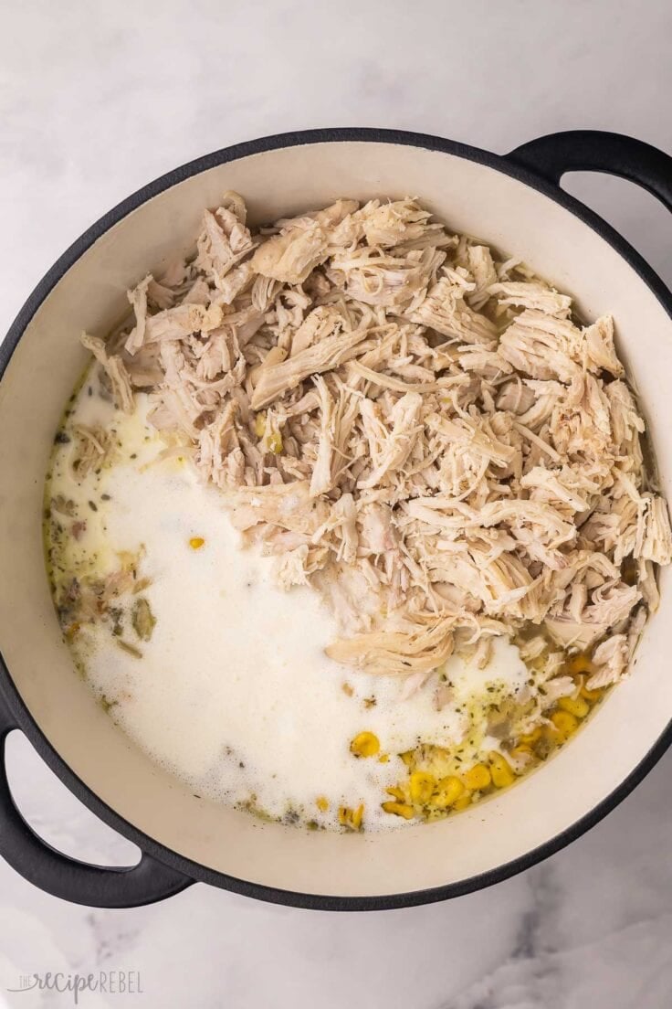 shredded chicken added to soup pot with other ingredients.