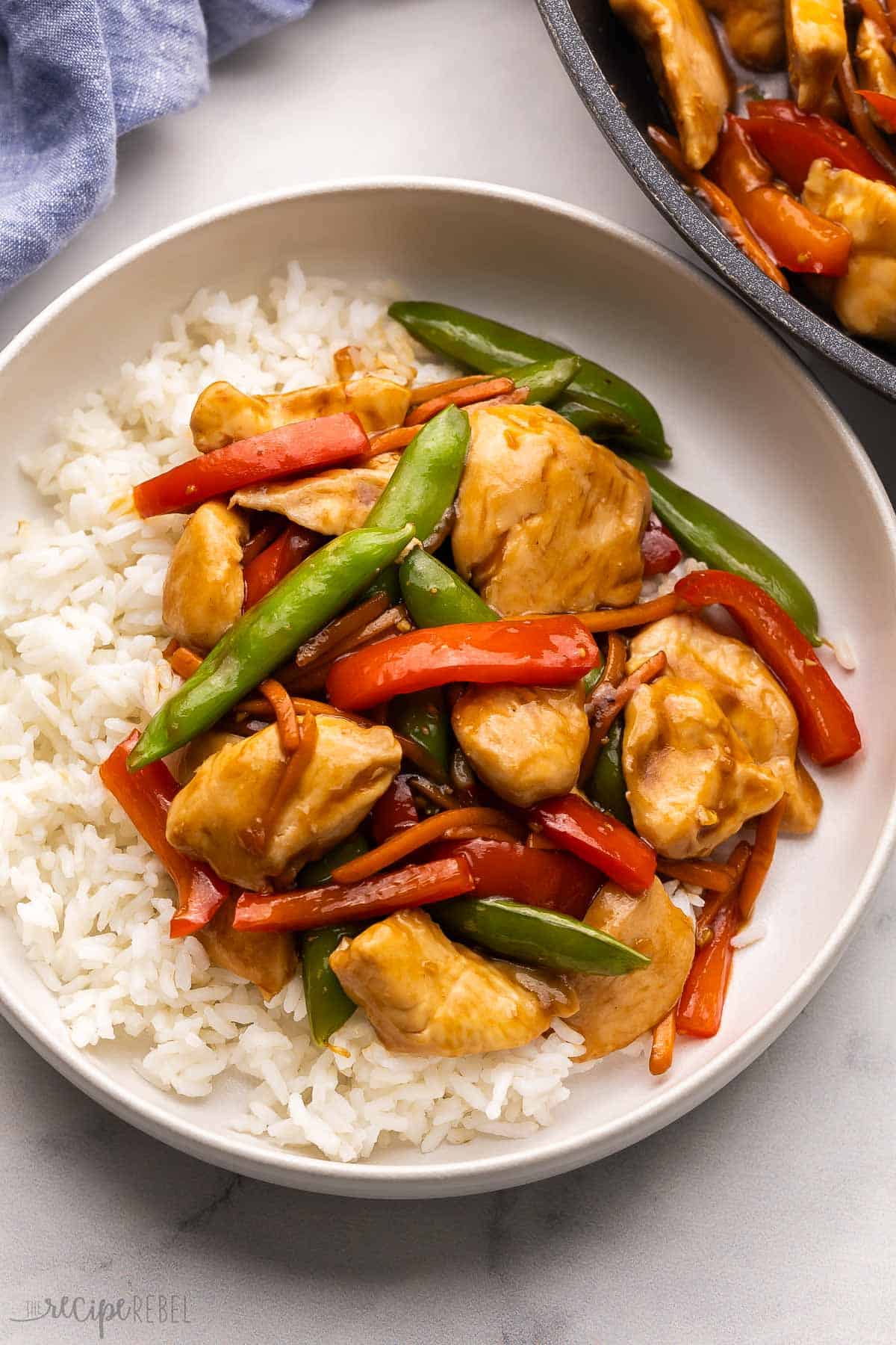 bowl with white rice topped with chicken stirfry.