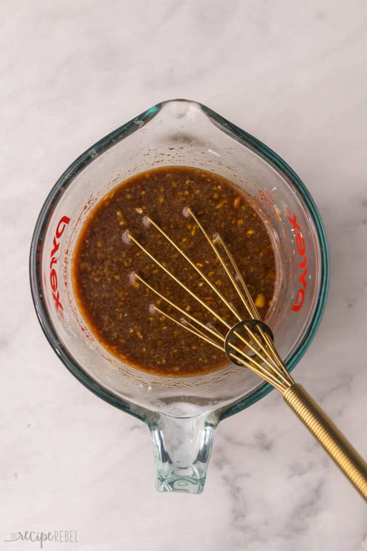 glass measuring cup with wet ingredients and whisk.