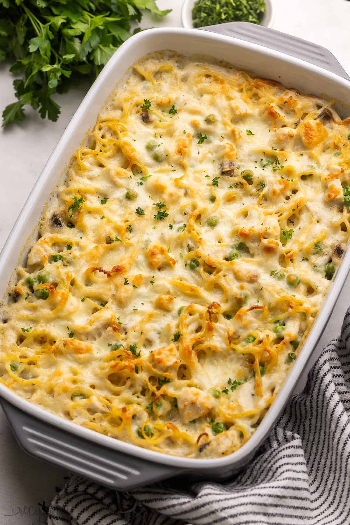 large pan of baked chicken tetrazzini with towel beside.