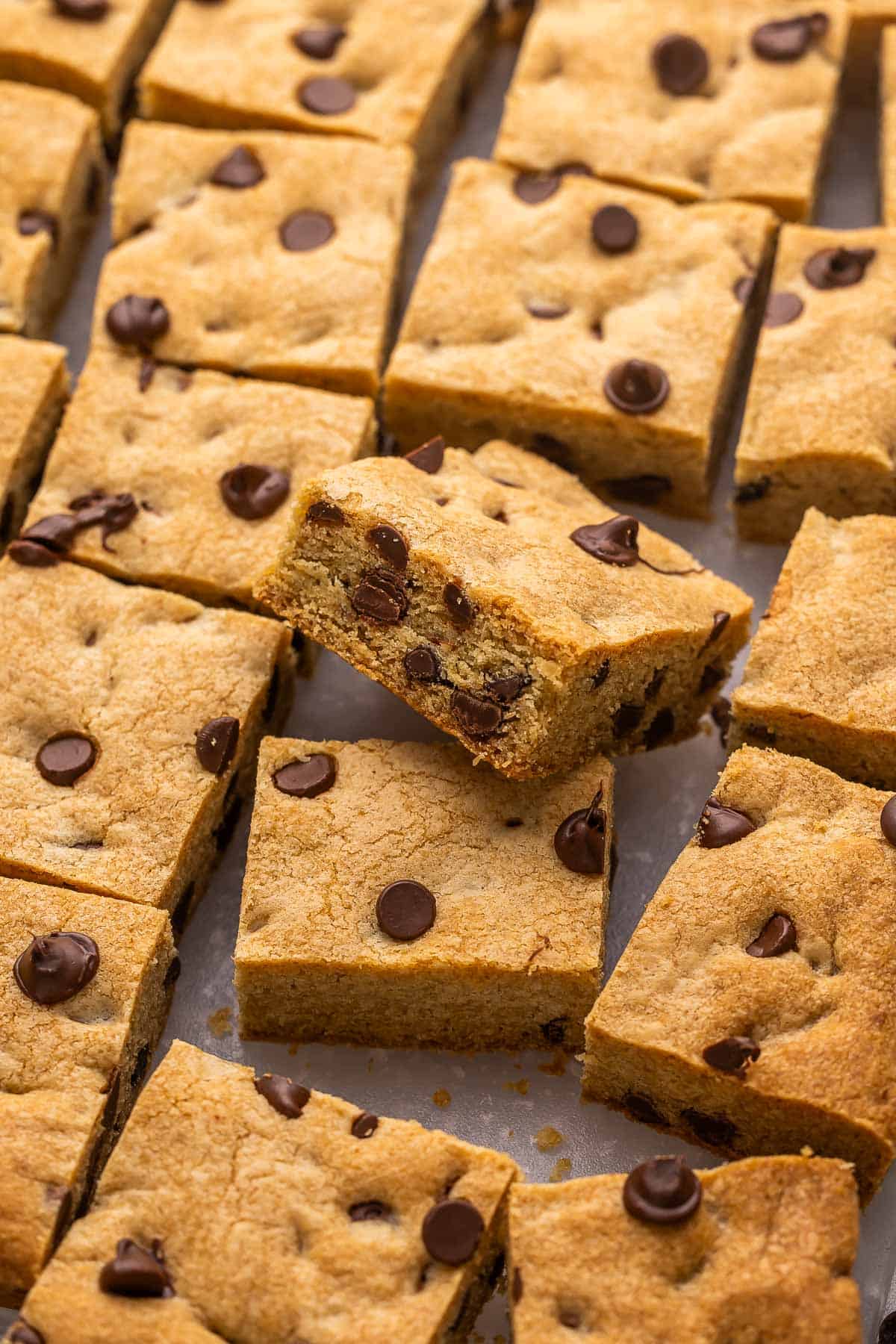 sliced chocolate chip cookie bars on a cutting board.